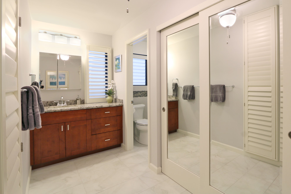 Large world-inspired ensuite bathroom in Hawaii with shaker cabinets, dark wood cabinets, a two-piece toilet, white tiles, white walls, a submerged sink and granite worktops.