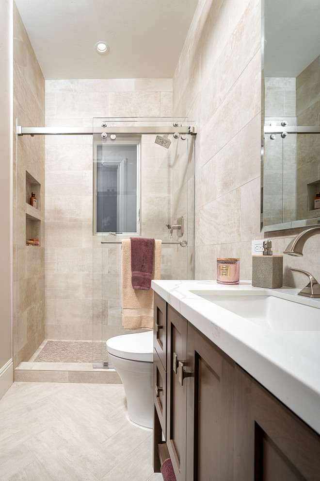 Exempel på ett litet klassiskt grå grått badrum med dusch, med släta luckor, svarta skåp, en öppen dusch, en toalettstol med hel cisternkåpa, grå kakel, porslinskakel, grå väggar, klinkergolv i porslin, ett undermonterad handfat, marmorbänkskiva, brunt golv och med dusch som är öppen