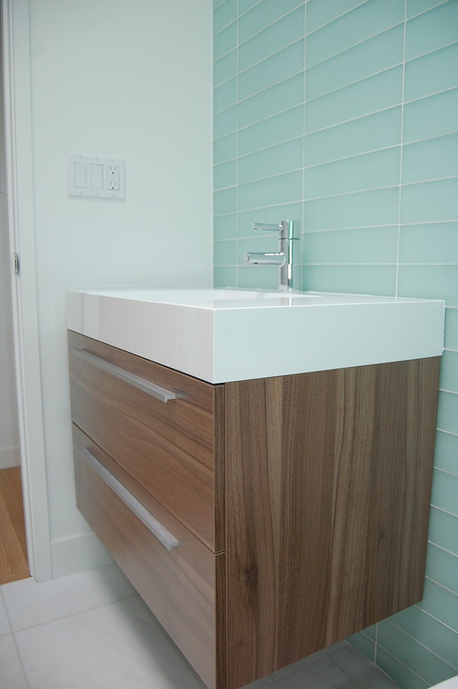 Ejemplo de cuarto de baño moderno pequeño con armarios con paneles lisos, puertas de armario de madera en tonos medios, ducha abierta, sanitario de una pieza, baldosas y/o azulejos de vidrio, suelo de mármol y lavabo integrado