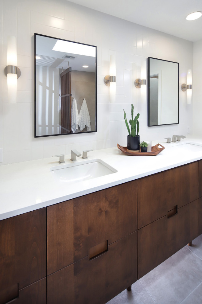 Exemple d'une salle de bain principale rétro en bois brun et bois de taille moyenne avec un placard à porte plane, une douche à l'italienne, WC à poser, un carrelage gris, des carreaux de porcelaine, un mur blanc, un sol en carrelage de porcelaine, un lavabo encastré, un plan de toilette en quartz modifié, un sol gris, aucune cabine, un plan de toilette blanc, une niche, meuble double vasque et meuble-lavabo encastré.