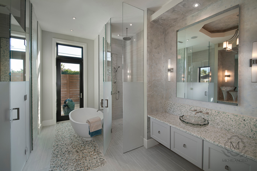 Imagen de cuarto de baño clásico renovado con lavabo sobreencimera, armarios con paneles empotrados, puertas de armario grises, encimera de cemento, bañera exenta y sanitario de una pieza
