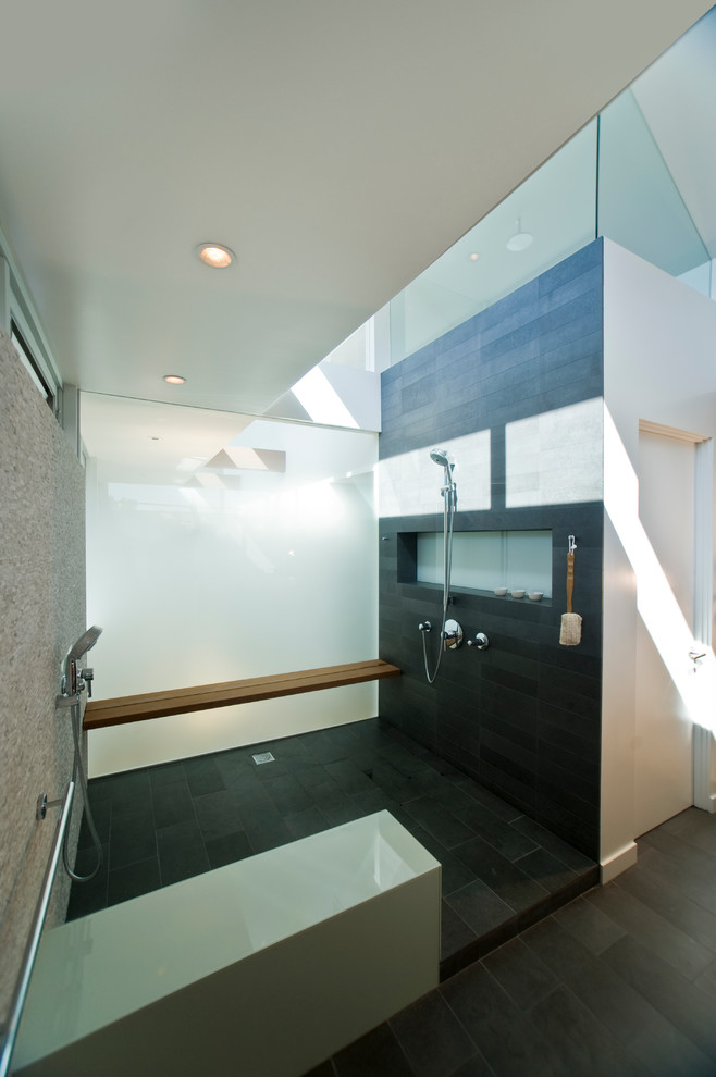 Réalisation d'une salle de bain design avec une douche double, un carrelage noir et une fenêtre.