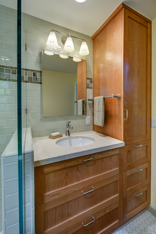 Пример оригинального дизайна: маленькая ванная комната в классическом стиле с врезной раковиной, фасадами в стиле шейкер, фасадами цвета дерева среднего тона, столешницей из искусственного кварца, угловым душем, раздельным унитазом, зеленой плиткой, керамической плиткой, желтыми стенами, полом из мозаичной плитки, белым полом, душем с раздвижными дверями, душевой кабиной, бежевой столешницей, нишей, сиденьем для душа, тумбой под одну раковину и встроенной тумбой для на участке и в саду