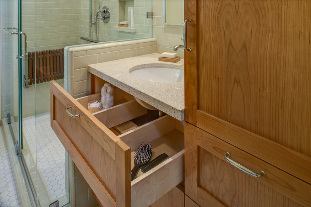 This is an example of a small traditional bathroom in San Francisco with a submerged sink, shaker cabinets, medium wood cabinets, engineered stone worktops, a corner shower, a two-piece toilet, green tiles, ceramic tiles, yellow walls, mosaic tile flooring, white floors and a sliding door.