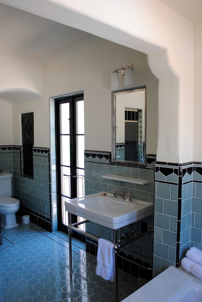 Inredning av ett klassiskt stort en-suite badrum, med ett badkar i en alkov, en dusch i en alkov, en toalettstol med hel cisternkåpa, svart kakel, blå kakel, porslinskakel, vita väggar, klinkergolv i porslin och ett piedestal handfat