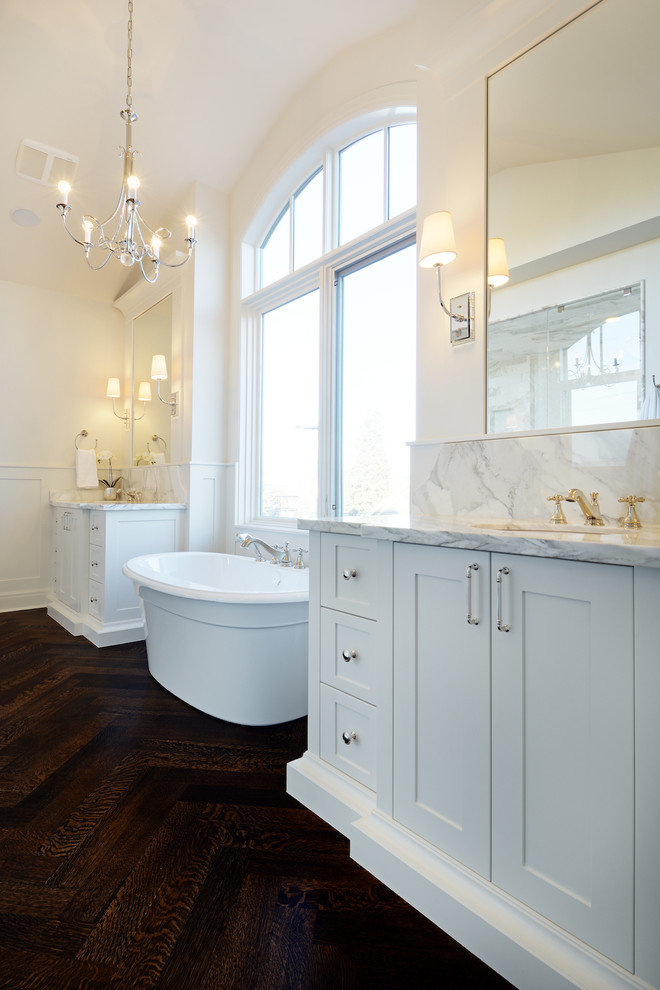 Idéer för ett klassiskt badrum, med marmorbänkskiva, ett fristående badkar och mörkt trägolv