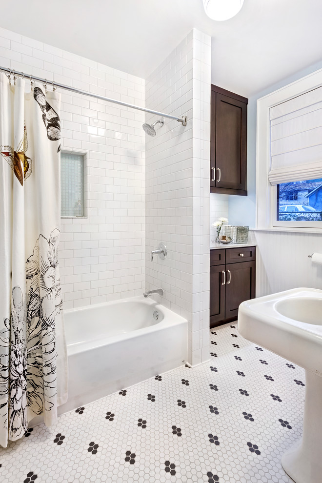 На фото: ванная комната среднего размера в стиле неоклассика (современная классика) с раковиной с пьедесталом, плиткой кабанчик, фасадами в стиле шейкер, темными деревянными фасадами, мраморной столешницей, ванной в нише, белой плиткой, синими стенами, полом из мозаичной плитки и душем над ванной с