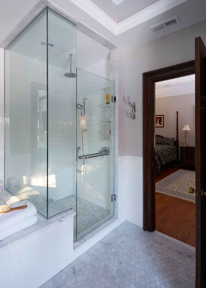 Cette photo montre une salle de bain principale chic en bois foncé de taille moyenne avec un placard à porte shaker, une baignoire encastrée, une douche d'angle, un carrelage blanc, un lavabo encastré, un carrelage métro, un mur beige, un sol en marbre et un plan de toilette en marbre.