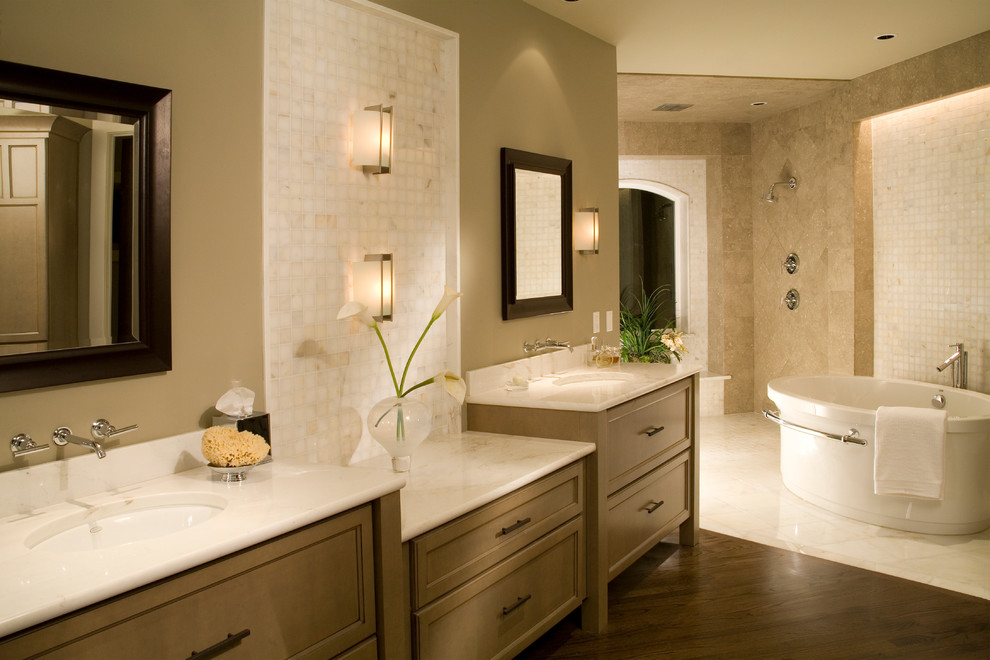 This is an example of a large traditional ensuite bathroom in Seattle with a submerged sink, beaded cabinets, medium wood cabinets, quartz worktops, a freestanding bath, a walk-in shower, beige tiles, stone tiles, beige walls and dark hardwood flooring.