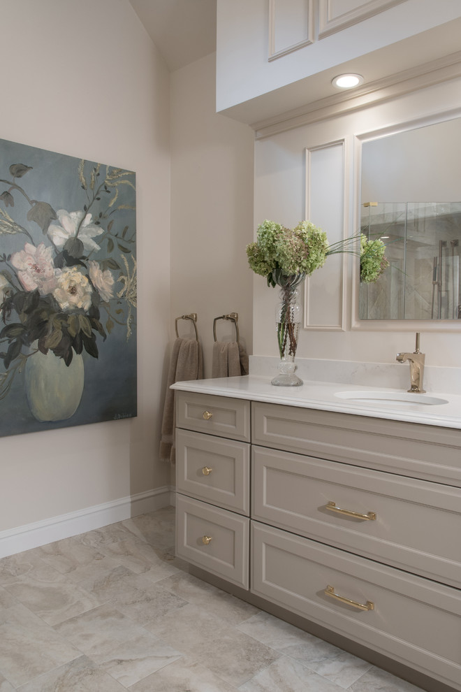 Example of a mid-sized classic master white tile and stone slab marble floor bathroom design in St Louis with raised-panel cabinets, white cabinets, a one-piece toilet, beige walls, a drop-in sink and solid surface countertops
