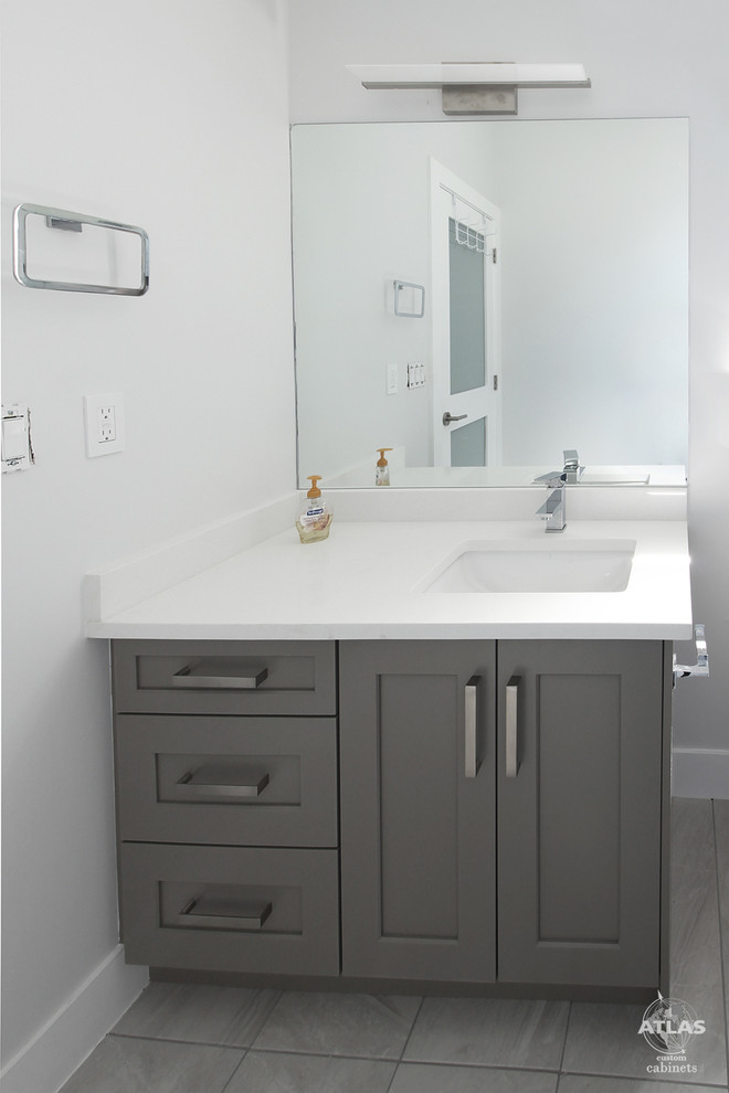 Immagine di una piccola stanza da bagno padronale contemporanea con lavabo sottopiano, ante in stile shaker, ante grigie, top in quarzite, WC monopezzo, pareti beige e pavimento in gres porcellanato