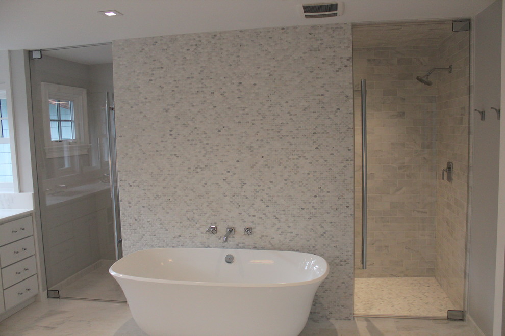 Inredning av ett klassiskt badrum, med ett fristående badkar, en kantlös dusch, flerfärgad kakel och marmorgolv