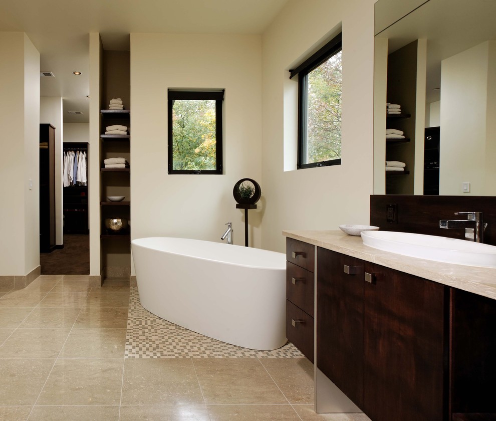 Стильный дизайн: большая главная ванная комната в современном стиле с плоскими фасадами, темными деревянными фасадами, отдельно стоящей ванной, бежевыми стенами, полом из керамогранита, накладной раковиной и коричневым полом - последний тренд