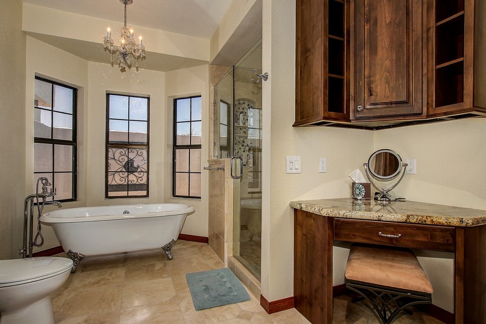 Mid-sized elegant master beige tile and stone tile travertine floor and beige floor bathroom photo in Phoenix with raised-panel cabinets, dark wood cabinets, a one-piece toilet, beige walls, an undermount sink, granite countertops and a hinged shower door