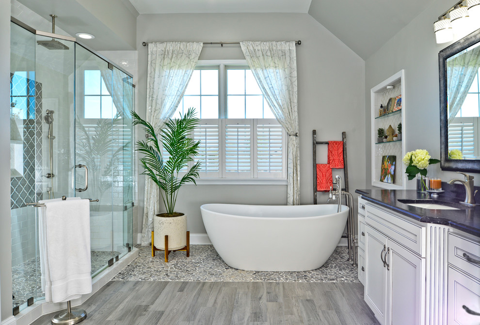 На фото: ванная комната с белыми фасадами, отдельно стоящей ванной, белой плиткой и столешницей из талькохлорита