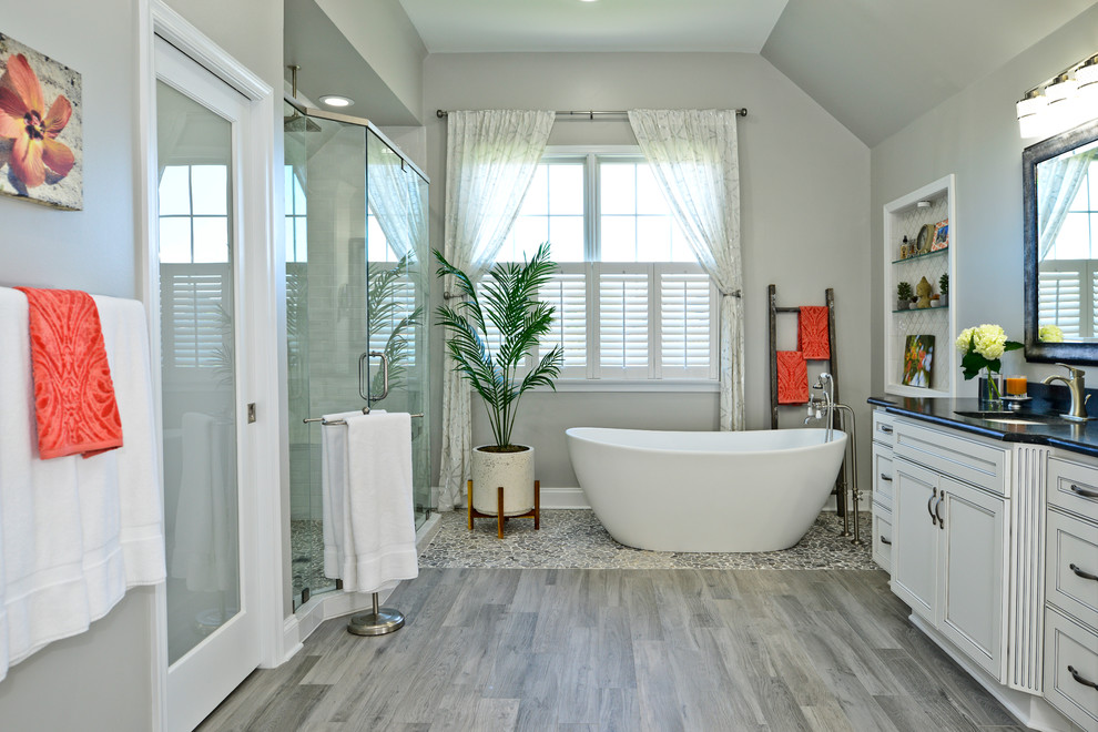 Idee per una stanza da bagno con ante bianche, vasca freestanding, piastrelle bianche e top in saponaria