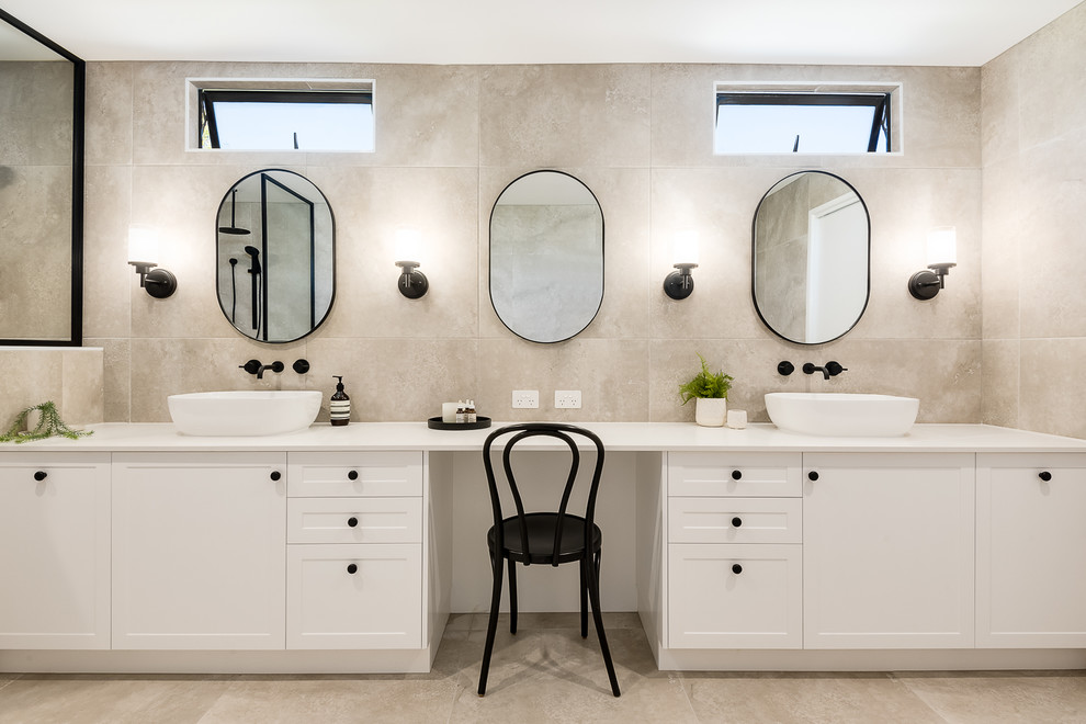 Large trendy master beige tile and porcelain tile porcelain tile and beige floor bathroom photo in Brisbane with shaker cabinets, white cabinets, a one-piece toilet, beige walls, a console sink, solid surface countertops and beige countertops