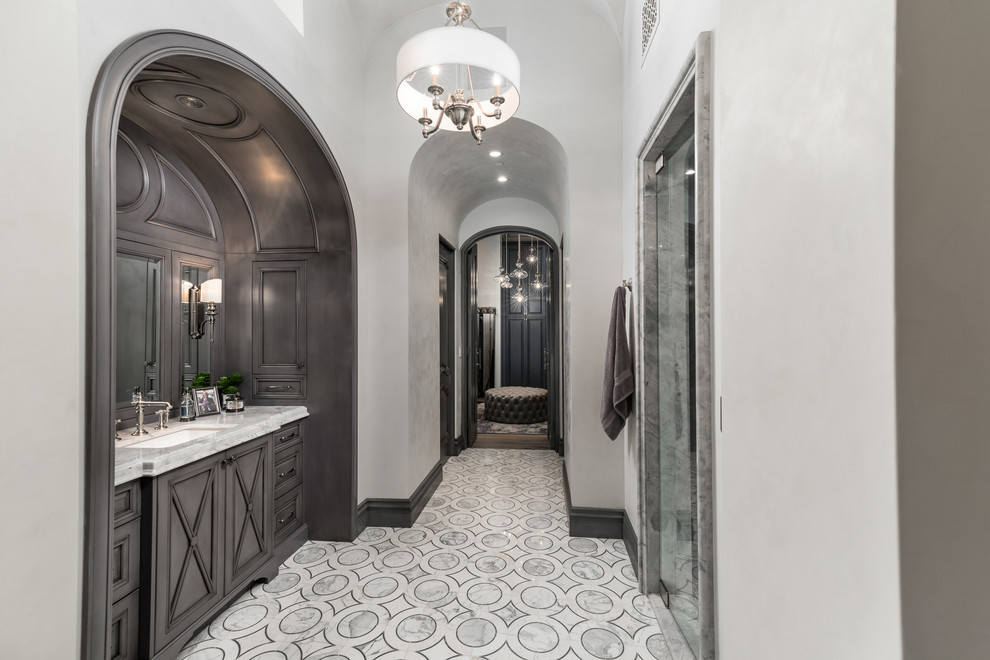 Expansive mediterranean ensuite bathroom in Phoenix with freestanding cabinets, grey cabinets, a built-in bath, an alcove shower, a two-piece toilet, white walls, porcelain flooring, a built-in sink, quartz worktops, multi-coloured floors, a hinged door and multi-coloured worktops.