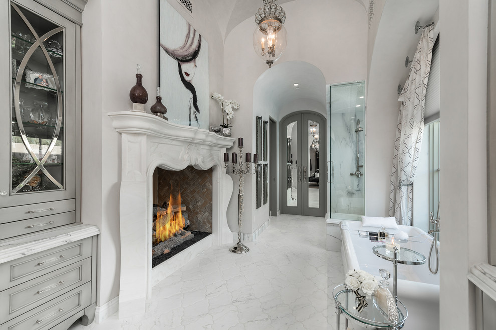 Идея дизайна: огромная главная ванная комната в средиземноморском стиле с серыми фасадами, отдельно стоящей ванной, угловым душем, полом из керамогранита, белыми стенами и белым полом