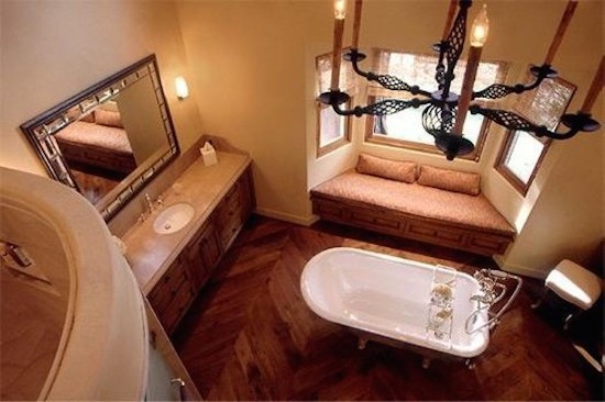 Immagine di una stanza da bagno padronale mediterranea di medie dimensioni con consolle stile comò, vasca con piedi a zampa di leone, piastrelle beige, pareti beige e lavabo da incasso