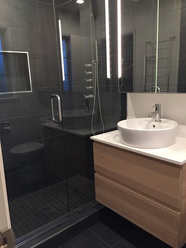 Idéer för ett mellanstort modernt badrum med dusch, med släta luckor, skåp i ljust trä, en dusch i en alkov, grå kakel, stenkakel, grå väggar, skiffergolv, ett fristående handfat och grått golv