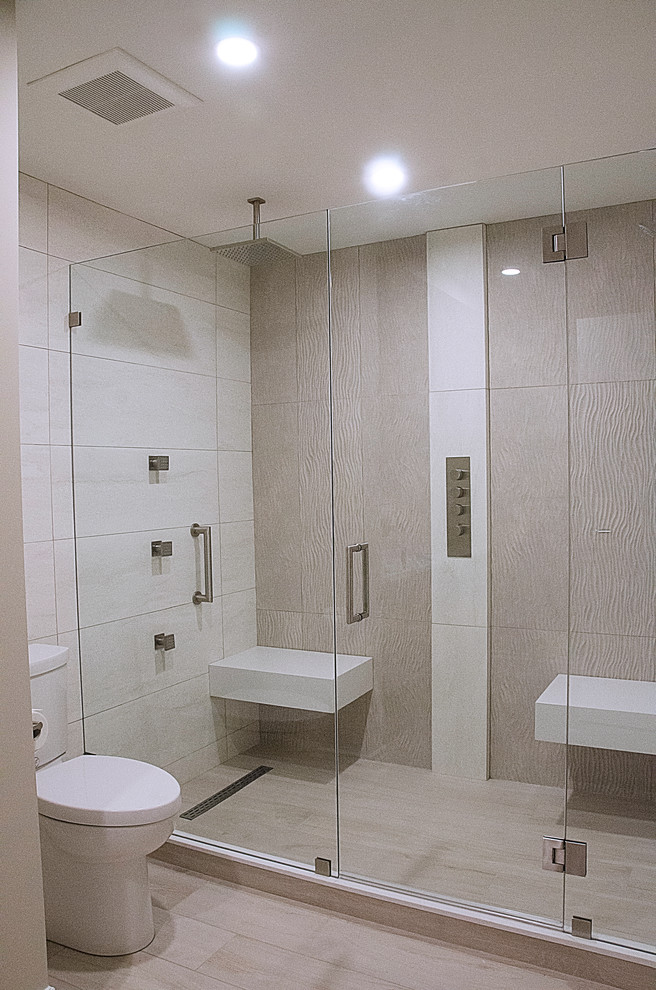 Пример оригинального дизайна: главная ванная комната в современном стиле с двойным душем, раздельным унитазом, бежевыми стенами, полом из керамогранита, бежевым полом и душем с распашными дверями