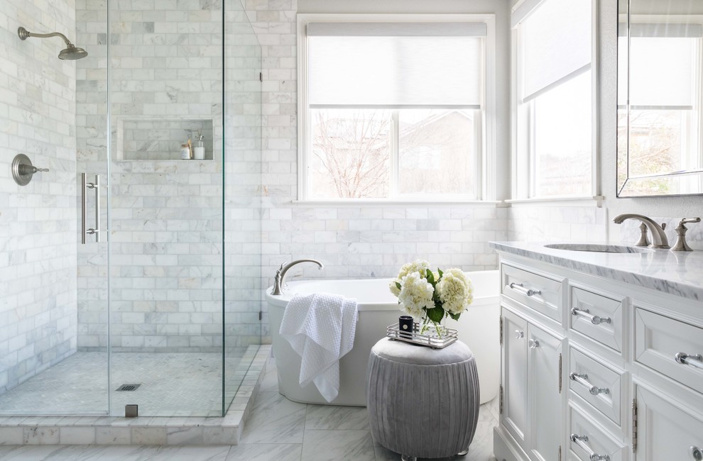 Foto på ett mellanstort vintage vit en-suite badrum, med vita skåp, ett fristående badkar, vit kakel, marmorkakel, grå väggar, marmorgolv, ett undermonterad handfat, marmorbänkskiva, vitt golv, dusch med gångjärnsdörr och luckor med infälld panel