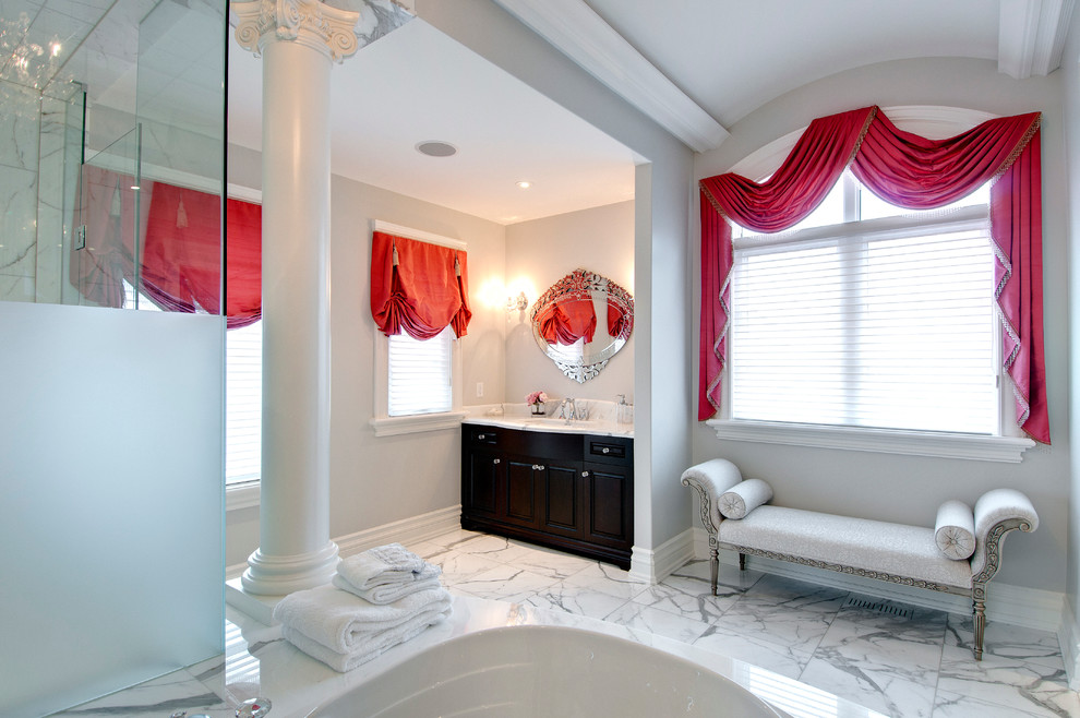 Diseño de cuarto de baño principal tradicional grande con ducha empotrada, sanitario de dos piezas, paredes grises, suelo de mármol, lavabo bajoencimera y ducha con puerta con bisagras