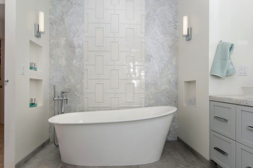 Пример оригинального дизайна: большая главная ванная комната в стиле модернизм с фасадами в стиле шейкер, серыми фасадами, отдельно стоящей ванной, белой плиткой, белыми стенами, полом из керамогранита, настольной раковиной, мраморной столешницей, серым полом, угловым душем, унитазом-моноблоком, керамогранитной плиткой и душем с распашными дверями
