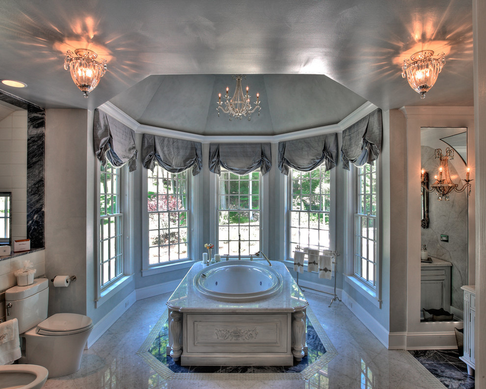 На фото: большая главная ванная комната в классическом стиле с накладной ванной, раздельным унитазом, серыми стенами, белыми фасадами, фасадами островного типа, настольной раковиной и окном