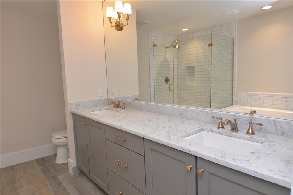 Foto på ett mellanstort vintage en-suite badrum, med vit kakel, skåp i shakerstil, grå skåp, marmorbänkskiva, tunnelbanekakel, ett platsbyggt badkar, en hörndusch, klinkergolv i porslin, ett undermonterad handfat och beige väggar