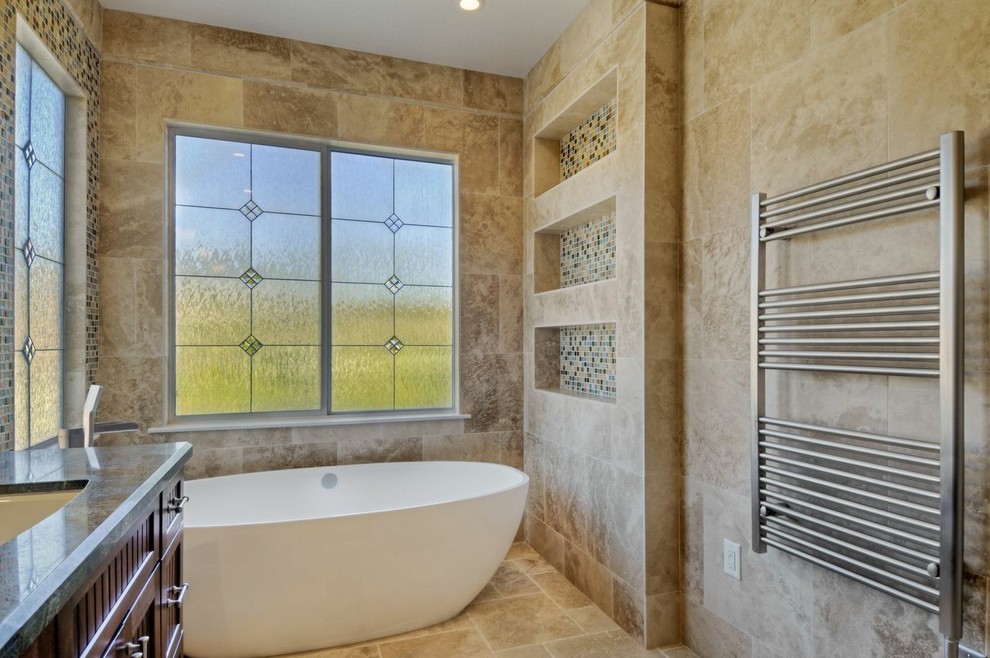 This is an example of a medium sized contemporary ensuite bathroom in San Diego with a submerged sink, beaded cabinets, dark wood cabinets, granite worktops, a freestanding bath, an alcove shower, a one-piece toilet, beige tiles, stone tiles, beige walls and travertine flooring.