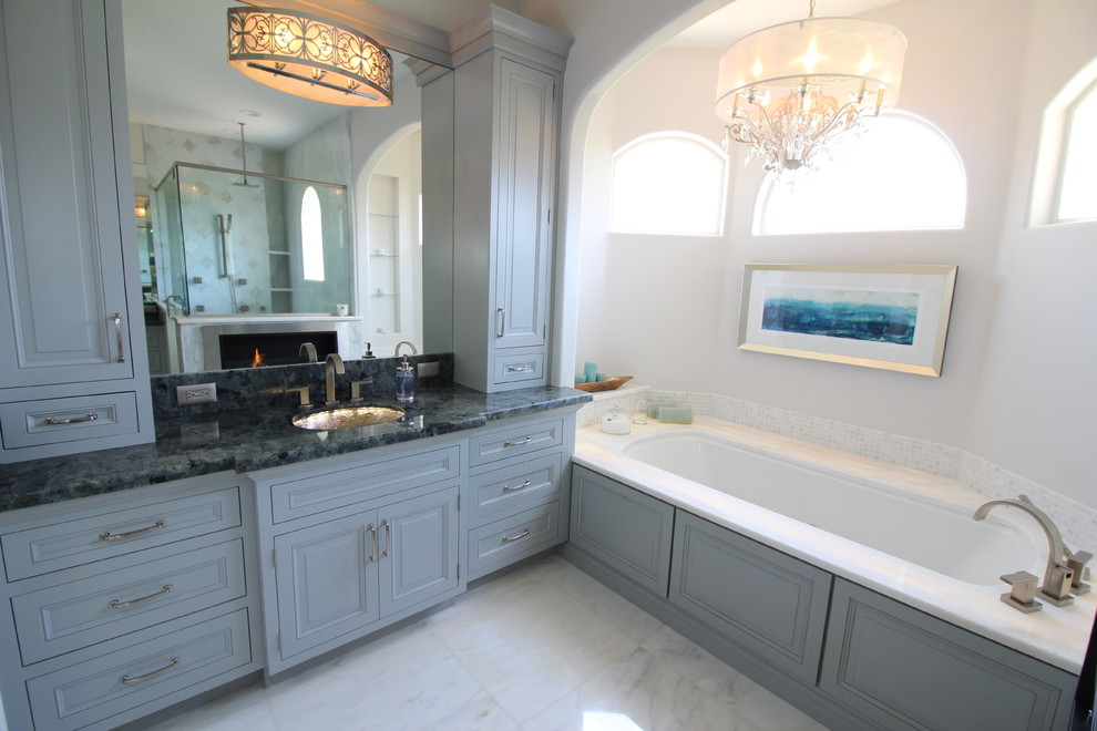 Exempel på ett stort modernt en-suite badrum, med luckor med upphöjd panel, grå skåp, ett undermonterat badkar, grå kakel, stenkakel, marmorgolv, beige väggar, ett undermonterad handfat och marmorbänkskiva