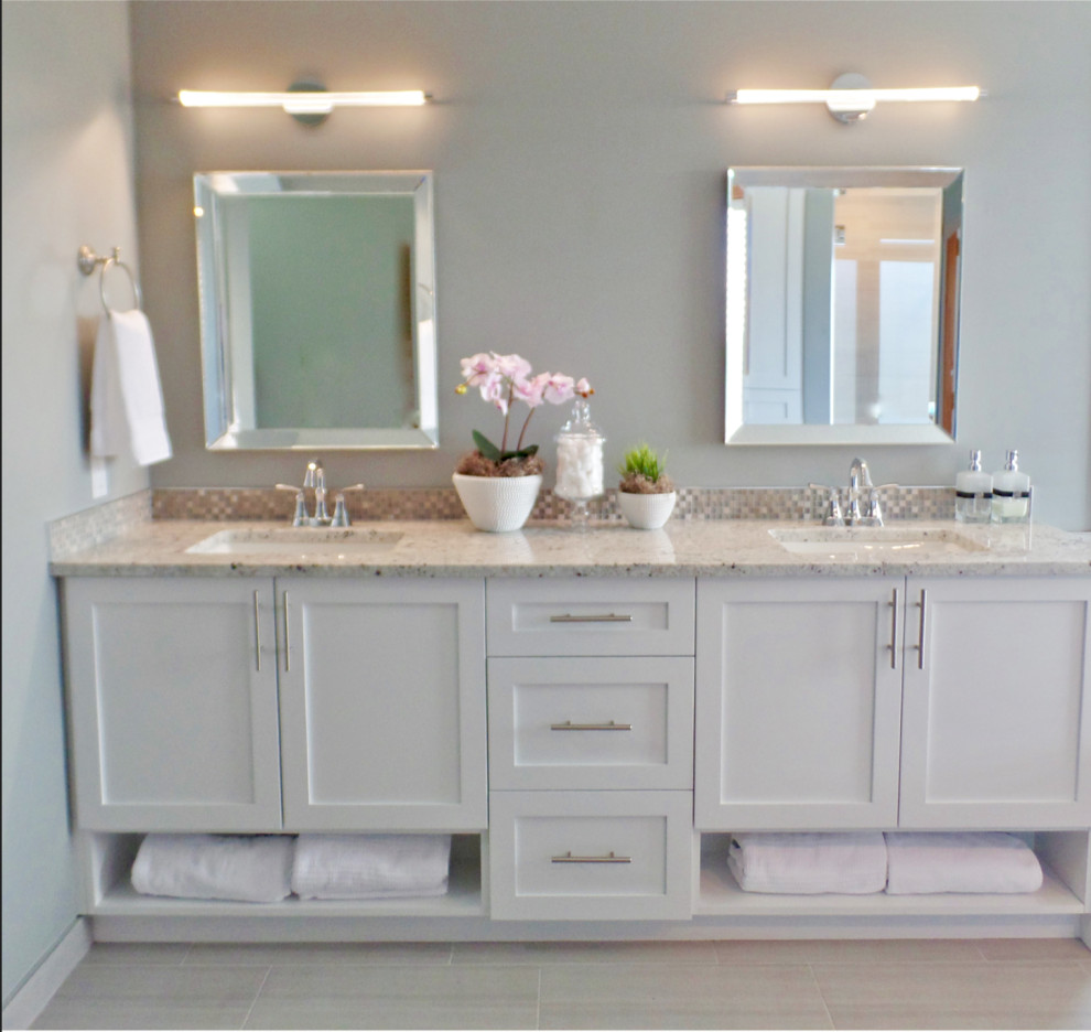Klassisk inredning av ett mellanstort en-suite badrum, med skåp i shakerstil, vita skåp, grå kakel, porslinskakel, grå väggar, klinkergolv i porslin, ett undermonterad handfat, granitbänkskiva, ett fristående badkar, en dusch i en alkov och en toalettstol med separat cisternkåpa