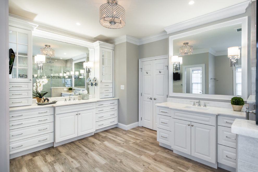 Inspiration for a large transitional master multicolored tile and porcelain tile porcelain tile and brown floor freestanding bathtub remodel in DC Metro with raised-panel cabinets, white cabinets, a two-piece toilet, gray walls, an undermount sink, marble countertops and white countertops