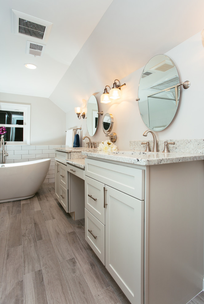 Immagine di una stanza da bagno chic con lavabo sottopiano, ante in stile shaker, ante bianche, pareti bianche, vasca freestanding, parquet scuro e pavimento marrone