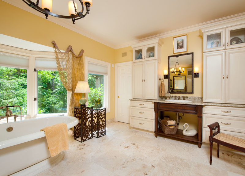 Идея дизайна: огромная главная ванная комната в классическом стиле с фасадами с утопленной филенкой, белыми фасадами, врезной раковиной, столешницей из гранита, отдельно стоящей ванной, белой плиткой и желтыми стенами