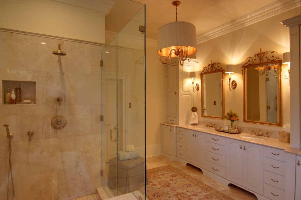 Idéer för att renovera ett mellanstort vintage en-suite badrum, med luckor med upphöjd panel, vita skåp, ett platsbyggt badkar, en dusch i en alkov, en toalettstol med hel cisternkåpa, beige kakel, brun kakel, porslinskakel, beige väggar, travertin golv, ett undermonterad handfat, marmorbänkskiva, beiget golv och dusch med gångjärnsdörr