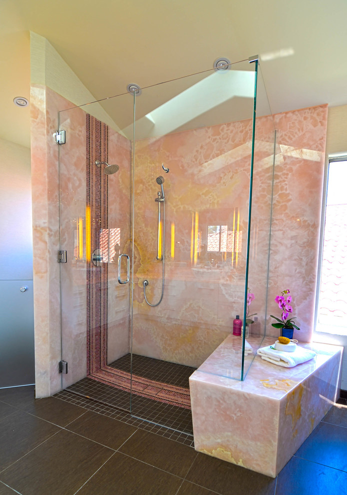 Exempel på ett stort modernt en-suite badrum, med ett fristående handfat, släta luckor, vita skåp, bänkskiva i onyx, ett fristående badkar, en kantlös dusch, en bidé, brun kakel, porslinskakel, vita väggar och klinkergolv i porslin
