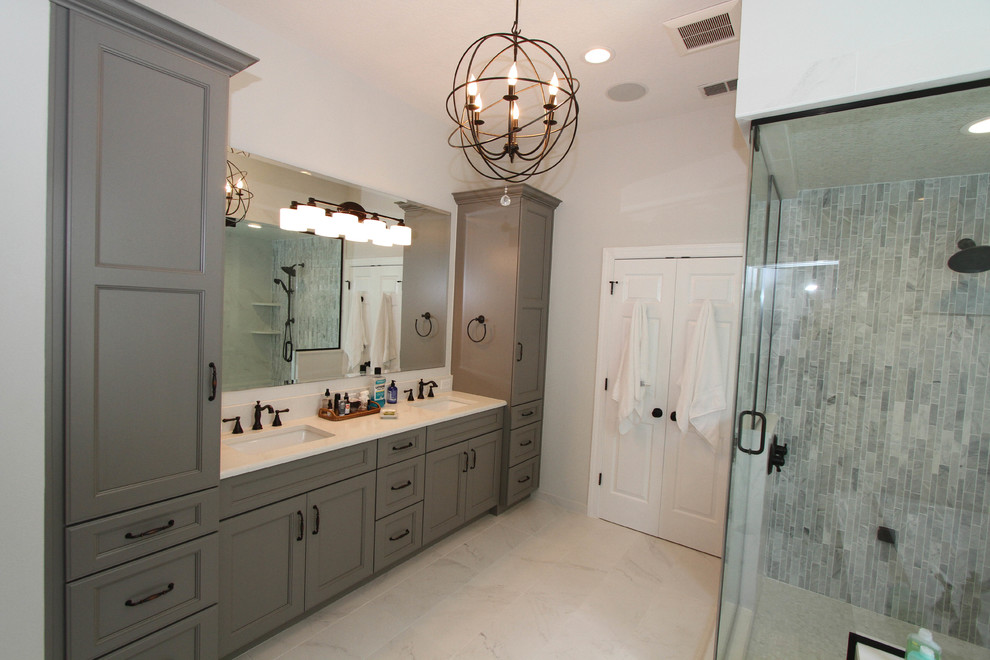 Large transitional master white tile and stone tile marble floor corner shower photo in Orlando with recessed-panel cabinets, gray cabinets, gray walls, an undermount sink and quartz countertops