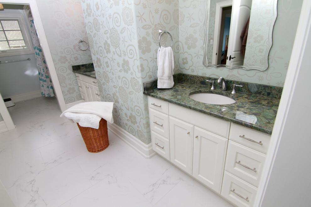 Exemple d'une salle de bain chic de taille moyenne avec un placard avec porte à panneau encastré, des portes de placard blanches, un combiné douche/baignoire, un mur bleu, un sol en marbre, un lavabo encastré et un plan de toilette en marbre.