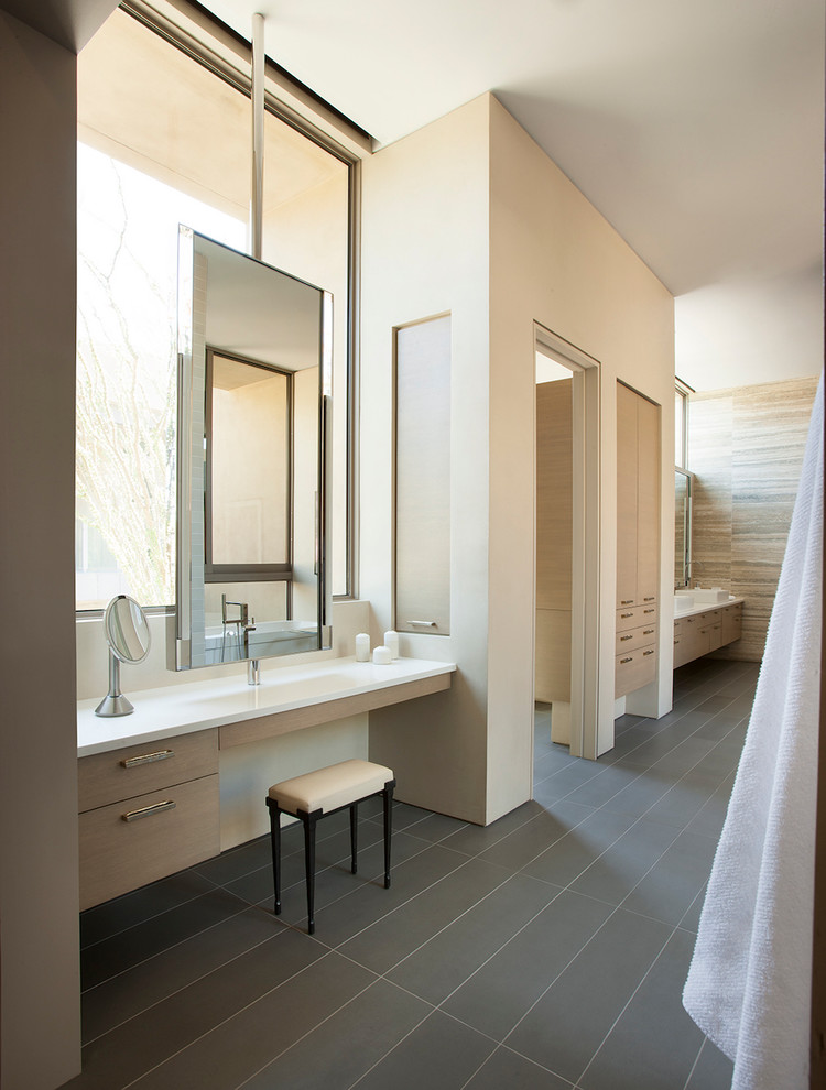 Идея дизайна: огромная главная ванная комната в стиле модернизм с плоскими фасадами, светлыми деревянными фасадами, отдельно стоящей ванной, душем в нише, серой плиткой, керамической плиткой, бежевыми стенами, полом из керамической плитки и столешницей из известняка