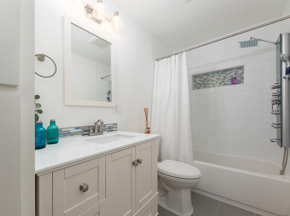 Idee per una stanza da bagno stile shabby di medie dimensioni con vasca da incasso, vasca/doccia, piastrelle bianche, piastrelle in gres porcellanato, pareti bianche, pavimento in gres porcellanato, pavimento grigio, doccia con tenda, ante in stile shaker, ante bianche, WC monopezzo, top in quarzite, top turchese e lavabo integrato