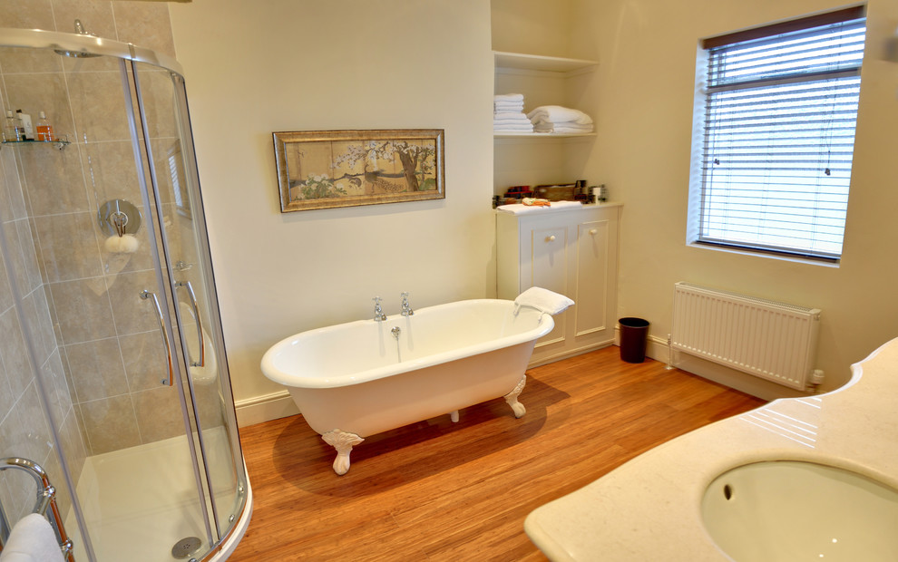 Cette photo montre une salle de bain chic pour enfant avec un placard à porte affleurante, une baignoire sur pieds, une douche d'angle, un mur vert et parquet en bambou.