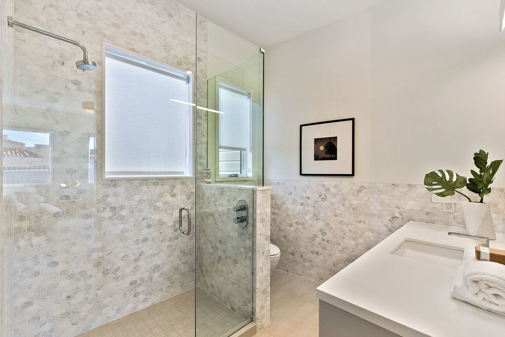 Идея дизайна: ванная комната среднего размера в современном стиле с двойным душем, унитазом-моноблоком, серой плиткой, мраморной плиткой, серыми стенами, светлым паркетным полом, душевой кабиной, врезной раковиной, столешницей из искусственного кварца и душем с распашными дверями