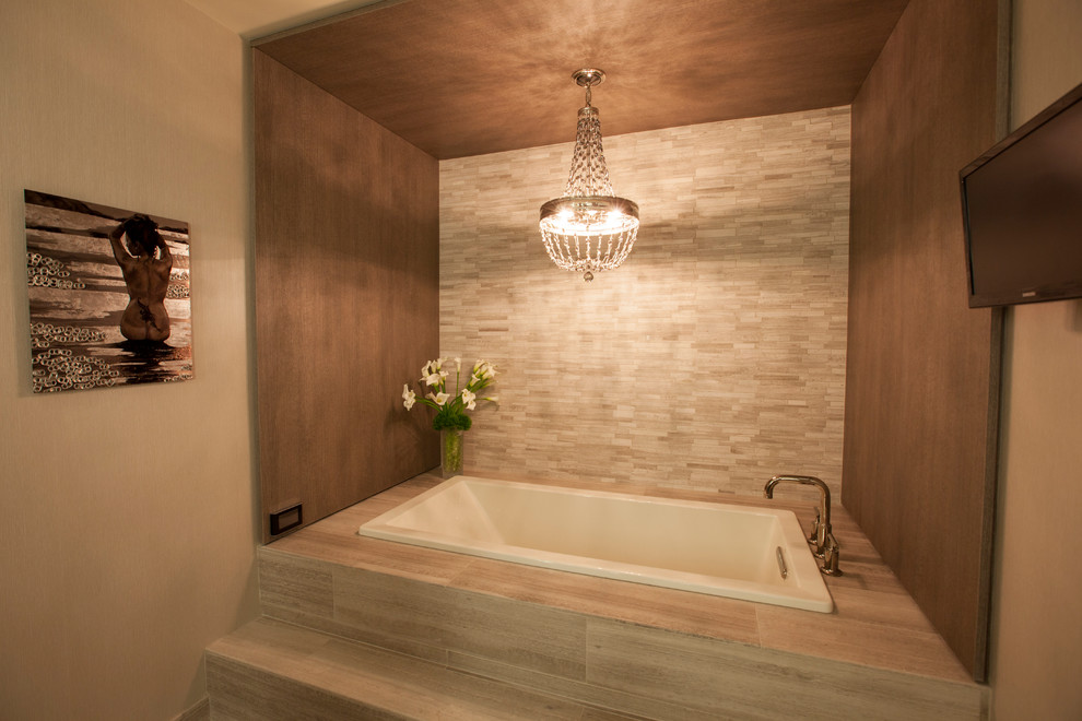 На фото: главная ванная комната в современном стиле с плоскими фасадами, серыми фасадами, гидромассажной ванной, открытым душем, плиткой из листового камня, серыми стенами, полом из известняка и столешницей из известняка с