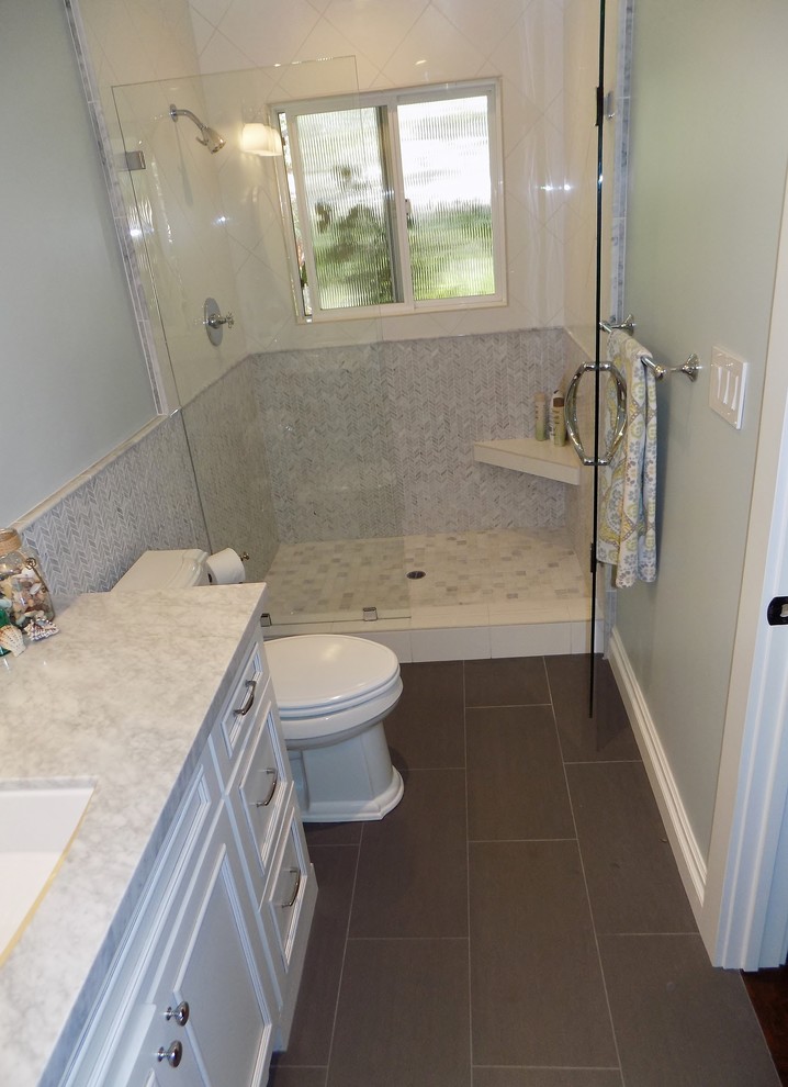 Imagen de cuarto de baño clásico renovado con armarios con paneles empotrados, puertas de armario blancas, encimera de mármol, baldosas y/o azulejos grises, baldosas y/o azulejos en mosaico y suelo de baldosas de porcelana