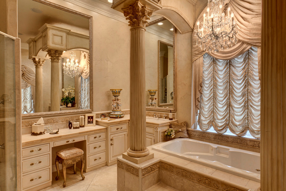 Klassisches Badezimmer mit profilierten Schrankfronten, beigen Schränken, Einbaubadewanne und beigen Fliesen in Sonstige