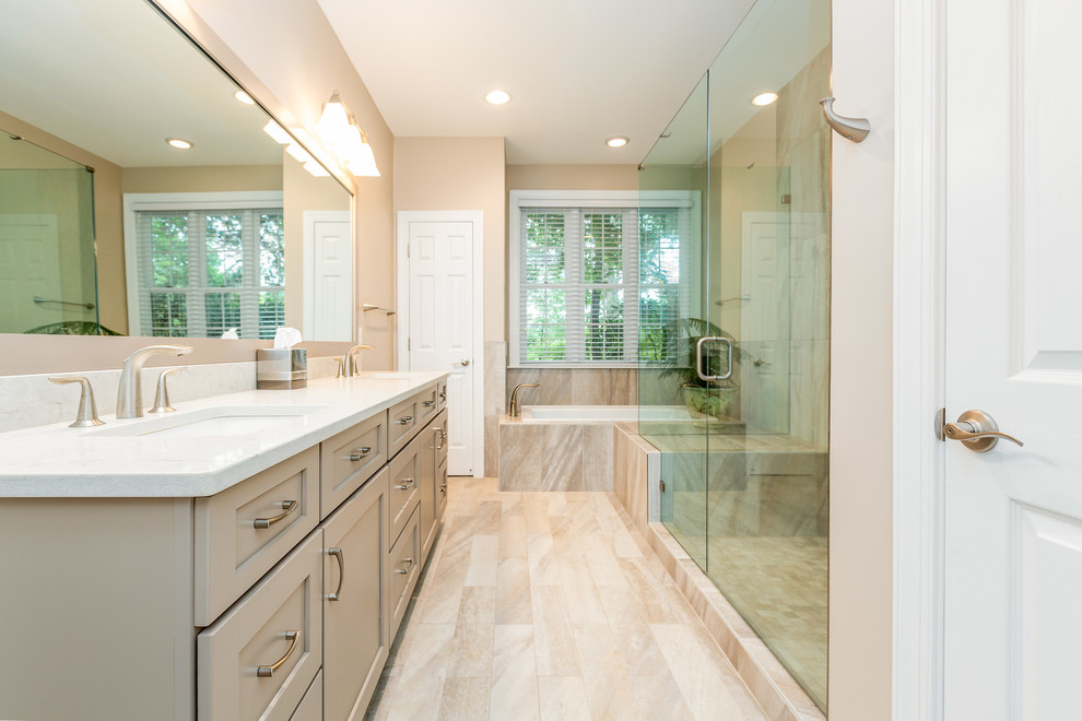 Inspiration for a traditional ensuite bathroom in DC Metro with recessed-panel cabinets, beige cabinets, a built-in bath, a corner shower, beige tiles, beige walls, a submerged sink, beige floors, a hinged door and white worktops.