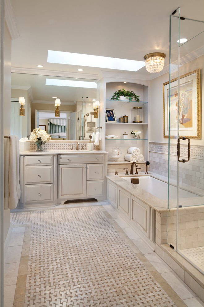 Идея дизайна: ванная комната в классическом стиле с фасадами с выступающей филенкой, бежевыми фасадами, полновстраиваемой ванной, угловым душем, серой плиткой, плиткой кабанчик, мраморным полом, разноцветным полом и душем с распашными дверями
